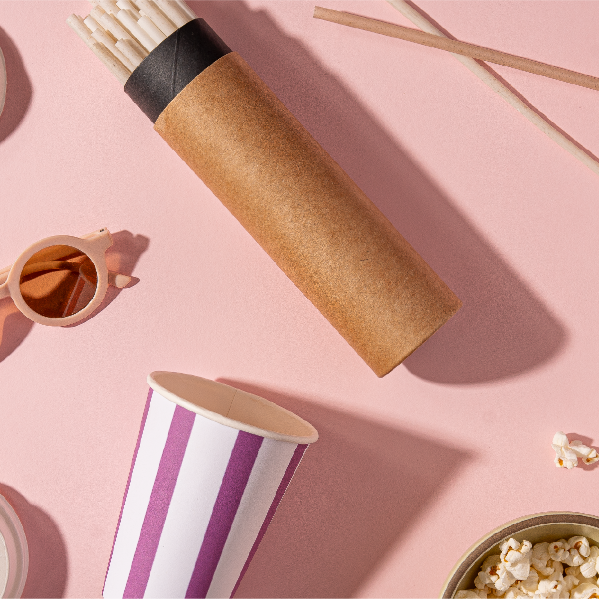 Compostable agave straws in craft carrying case next to compostable cup, sunglasses and popcorn