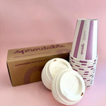 Branded box next to a stack of Sproutable mauve stripped 12oz home compostable cups and compostable lid – plant fiber, home compostable, plastic-free