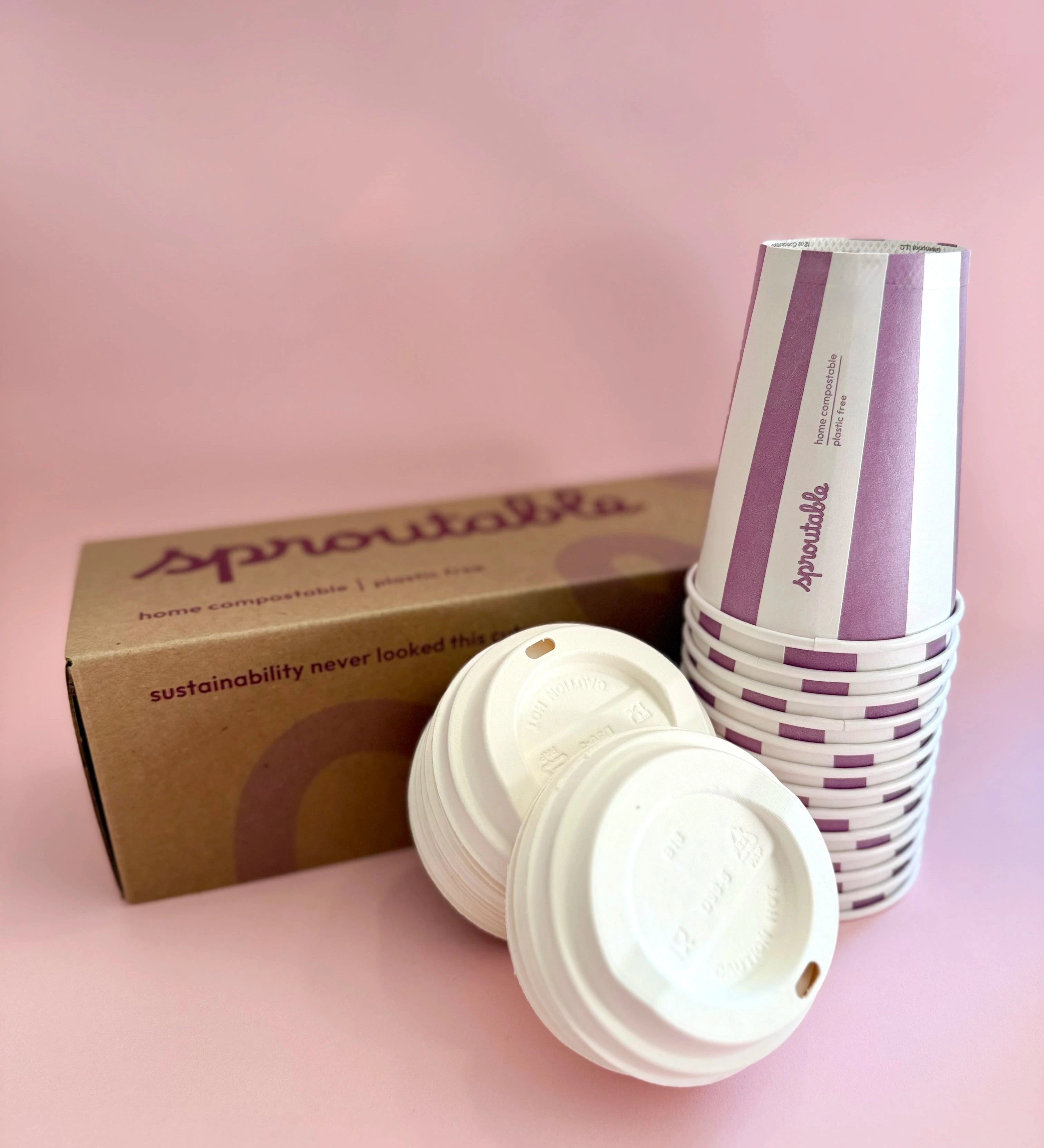 Branded box next to a stack of Sproutable mauve stripped 12oz home compostable cups and compostable lid – plant fiber, home compostable, plastic-free