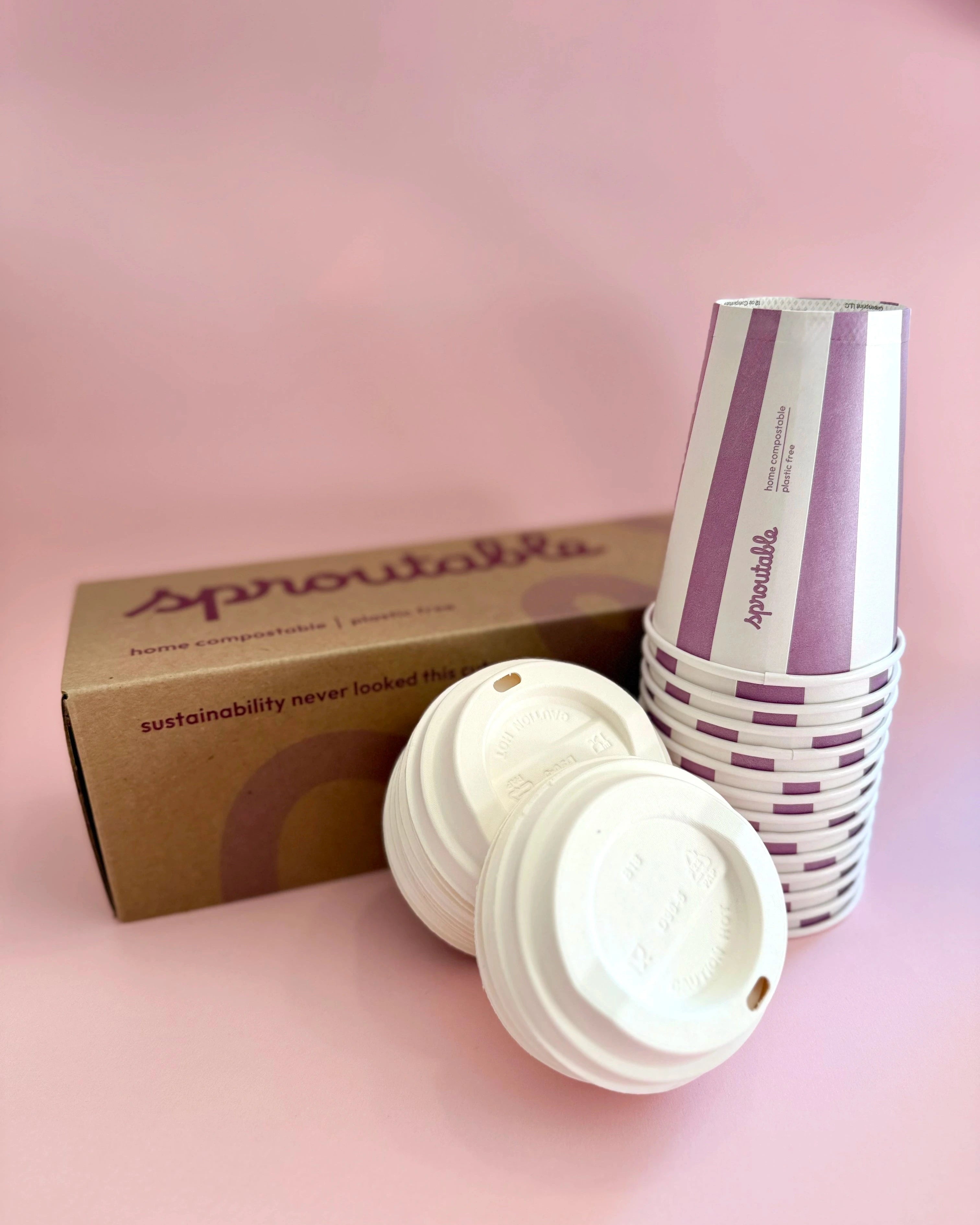 Branded box next to a stack of Sproutable mauve stripped 12oz home compostable cups and compostable lid – plant fiber, home compostable, plastic-free